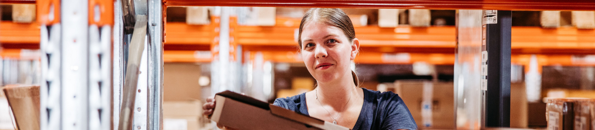 Female Gebrüder Weiss Warehouse Logistics employee holding a package