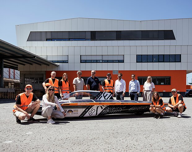 Studenci z zespołu aCentauri Solar Racing Team z ETH Zurich prezentują swój pojazd solarny w terminalu Air & Sea w Wolfurt – w towarzystwie przedstawicieli firmy Gebrüder Weiss.